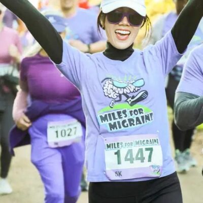 Woman crossing finish line at Migraine Walk