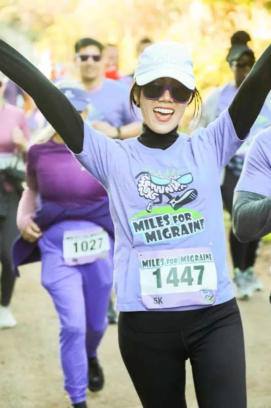 Woman crossing finish line at Migraine Walk